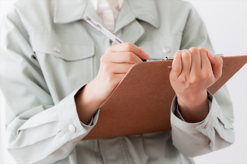 バインダーにメモをする作業員